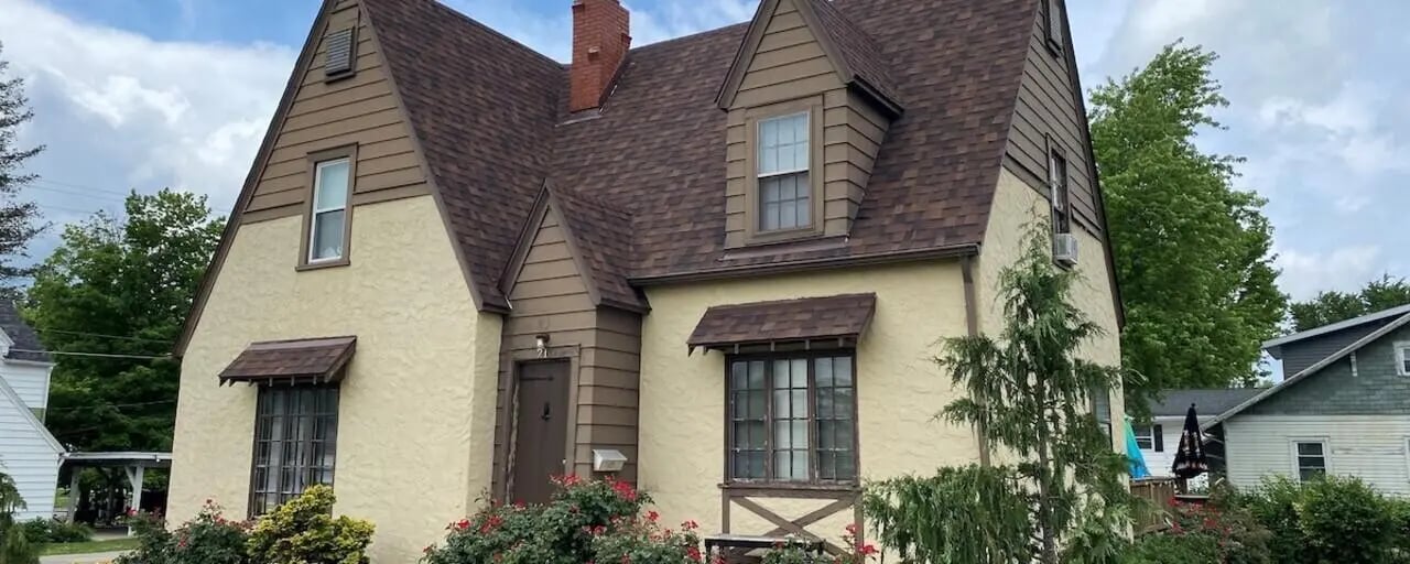 Tan stucco house with dormer windows exterior at Bowers Rentals in Charleston Student Accommodation