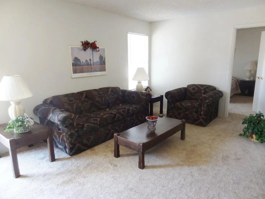 Sofa coffee table lamps armchair living room at Baylor Arms in Waco Student Accommodation