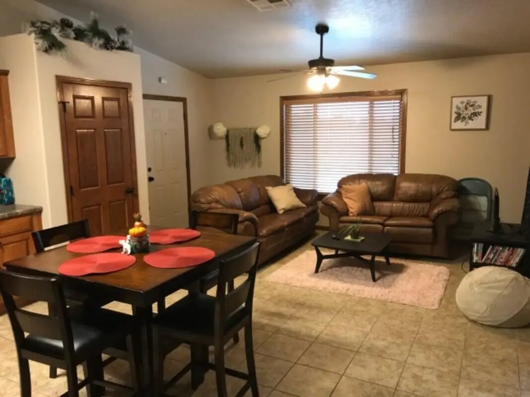 Leather sofas coffee table dining set living room at Clarks Landing Apartments in Vermillion Student Accommodation