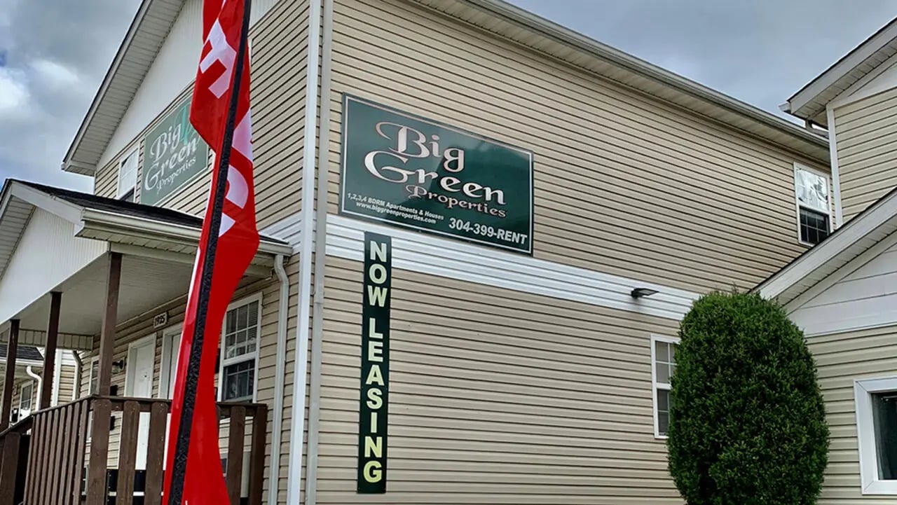 Big Green Properties building with red flag exterior at Big Green Properties, LLC in Huntington Student Accommodation