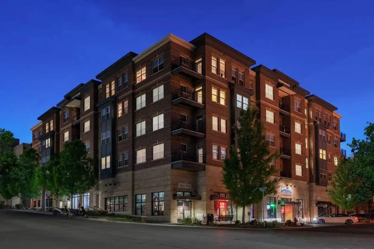Brick apartment building with lit windows and balconies exterior at Breckenridge Apartments Iowa City in Iowa City Student Accommodation
