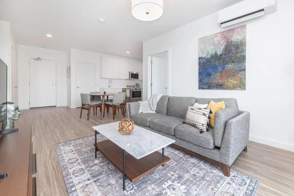 Grey sofa coffee table rug kitchen living room at 11 East Pleasant in Amherst Student Accommodation