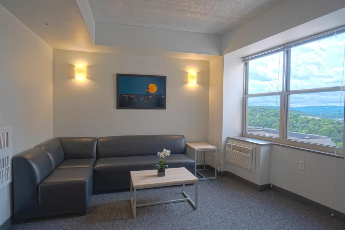Gray sectional couch coffee table living room at Collegetown Crossing in Ithaca Student Accommodation