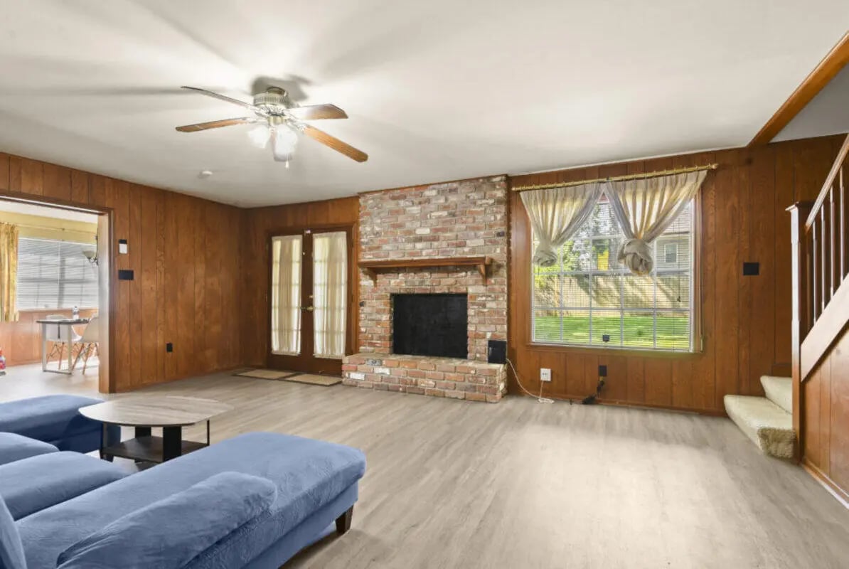 Blue sectional sofa fireplace and wood paneled living room at Cloud Living Student Housing in Houston Student Accommodation