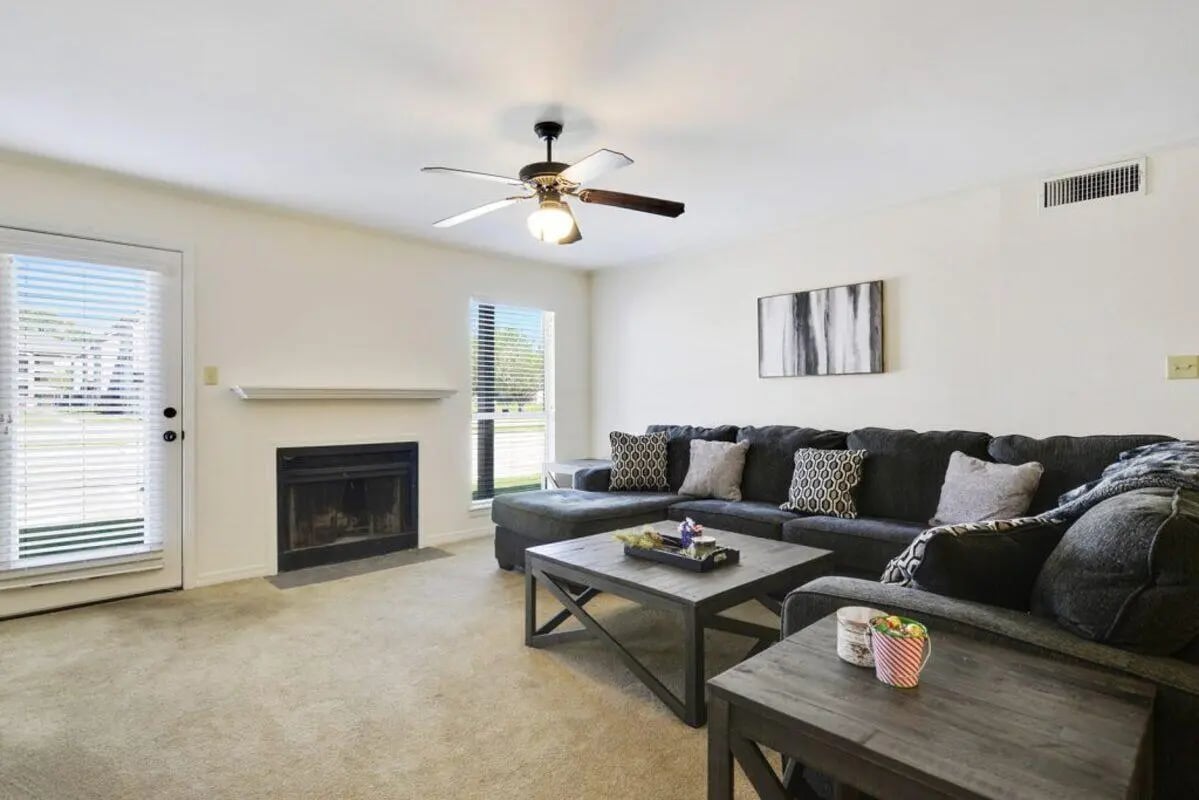 Dark sectional sofa fireplace and coffee table living room at Beau Chene Condominiums, Inc in Baton Rouge Student Accommodation