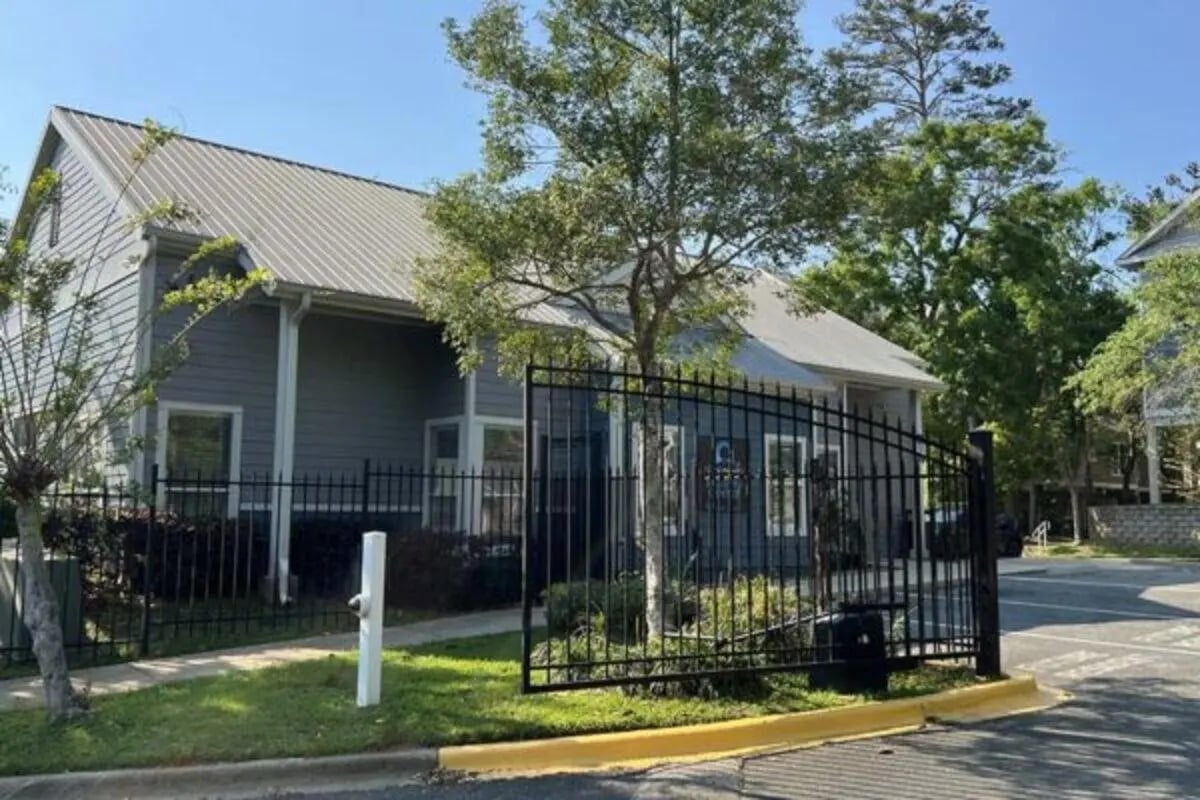 Gray building black fence and green lawn exterior at Altura Student Living in Tallahassee Student Accommodation