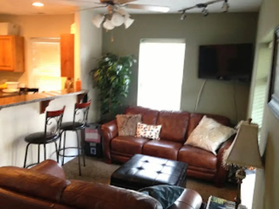 Leather sofa ottoman bar stools kitchen living area at City Creek Manor in Salt Lake City Student Accommodation