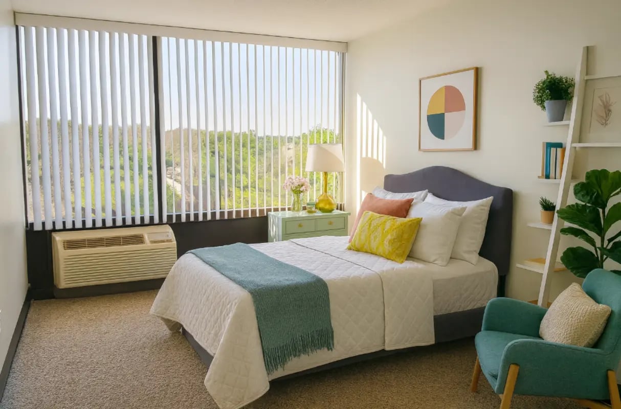 Bed with teal throw blanket armchair and decor Bedroom at City Lofts Apartments in Williamsburg Student Accommodation