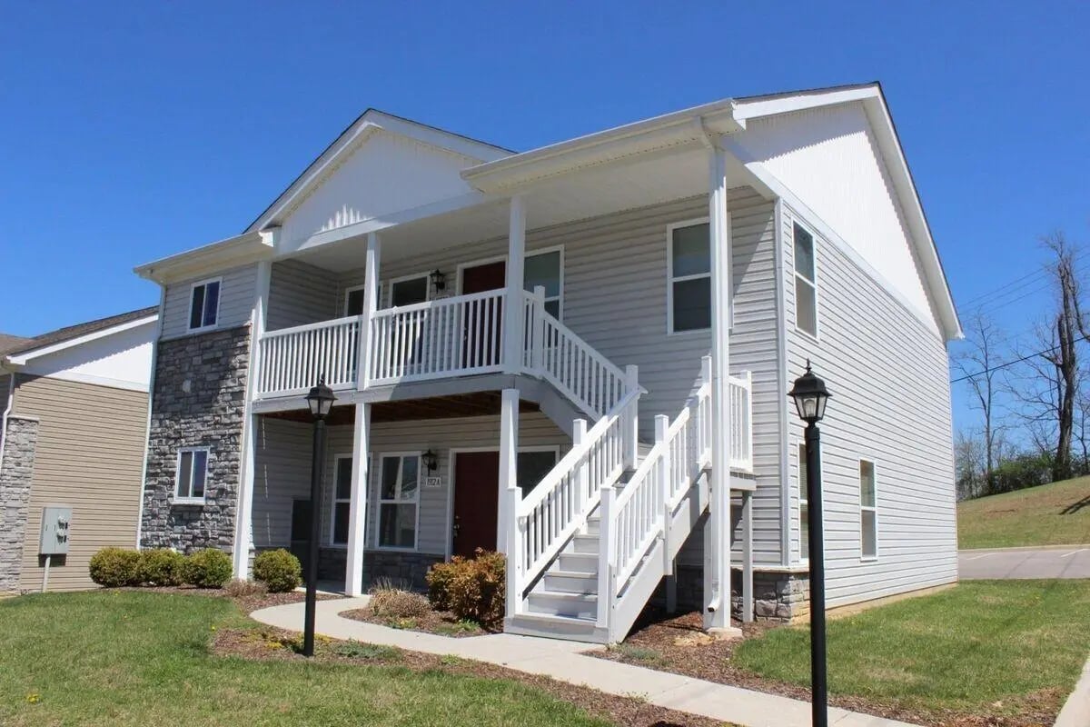 Gray siding building white stairs exterior at Collegiate Court in Blacksburg Student Accommodation