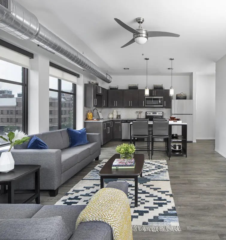 Sofa rug coffee table kitchen and bar stools living room at Vic Village North in Ann Arbor Student Accommodation