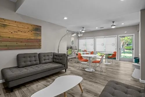 Gray sectional sofa with modern tables and chairs living room at The Spoke in Davis Student Accommodation
