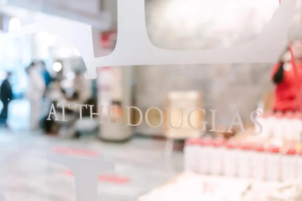Text "AT THE DOUGLAS" on glass exterior at The Douglas - Student Housing Apartments in Seattle Student Accommodation