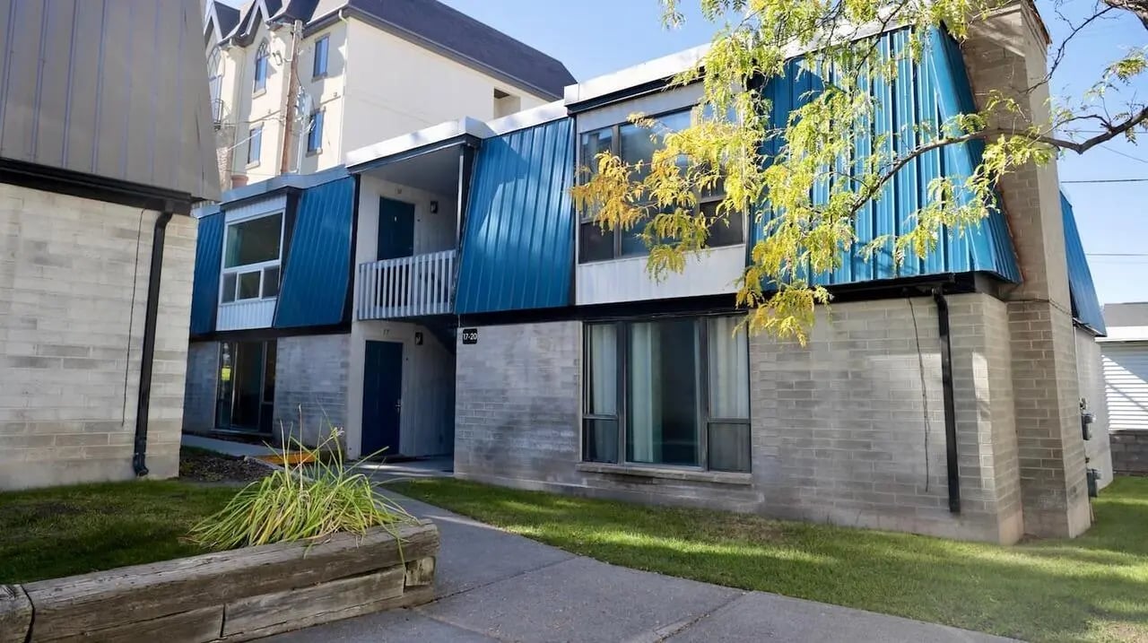 Blue metal siding apartments with brick exterior exterior at Haven White Apartments in Rexburg Student Accommodation