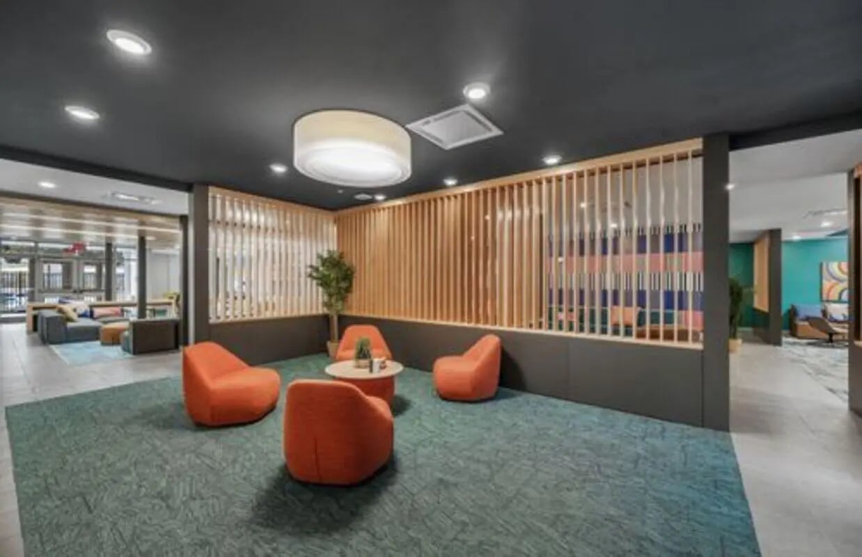 Orange chairs and table with modern decor common area at Aspen Heights Bloomington in Bloomington Student Accommodation