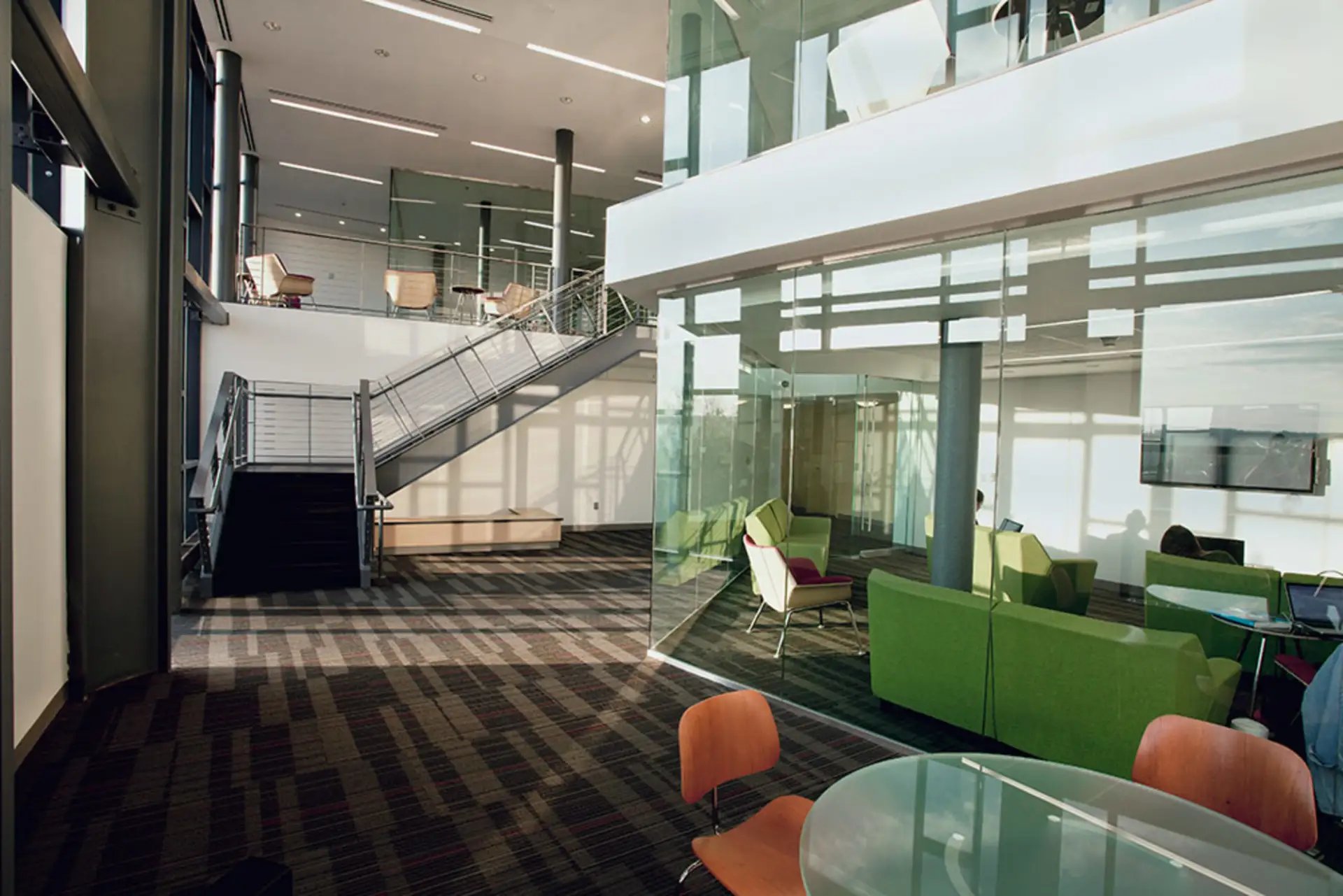 Modern common area with seating stairs and glass living room at Collegetown Terrace Apartments in Ithaca Student Accommodation