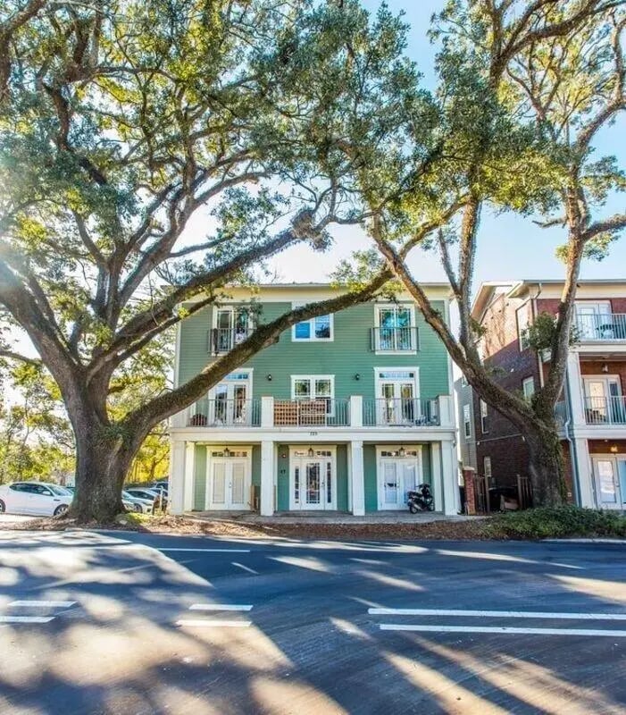 Green building balconies driveways and large trees exterior at CollegePlace FSU in Tallahassee Student Accommodation