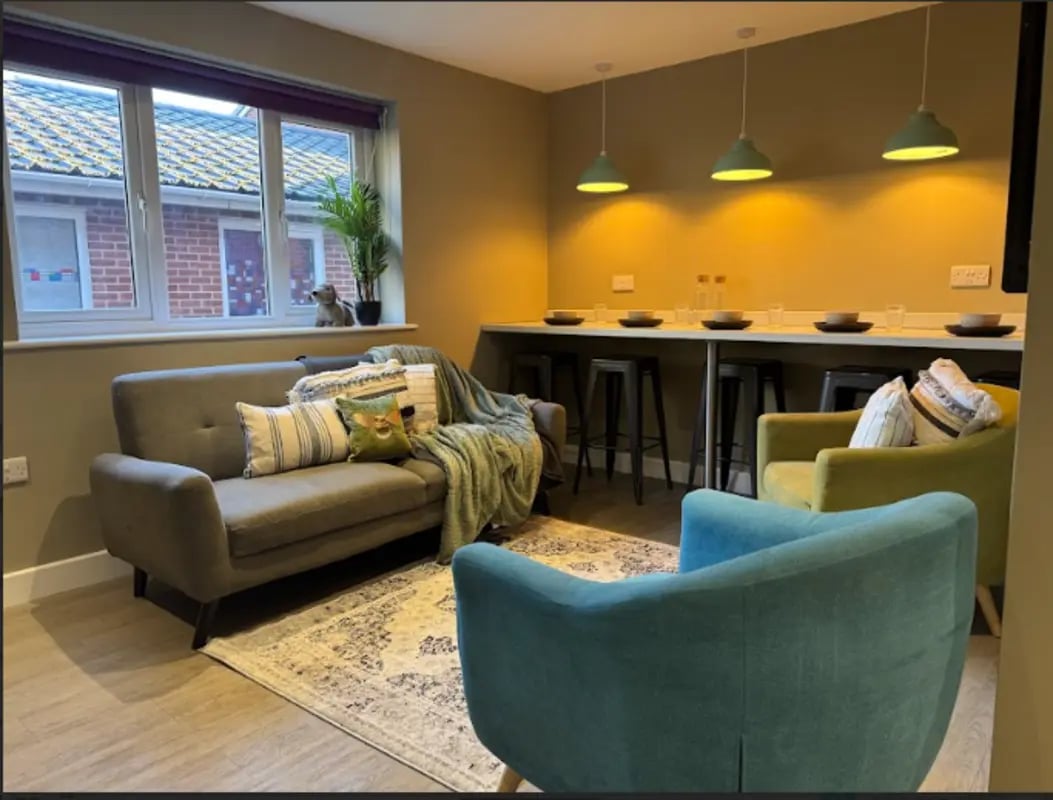 Sofas chairs rug with bar seating area living room at Varsity Beeston in Nottingham Student Accommodation
