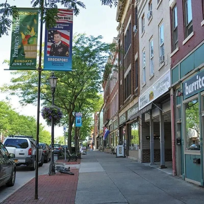 Street with shops and parked cars exterior at Brockport Crossings Apartments & Townhomes in Brockport Student Accommodation