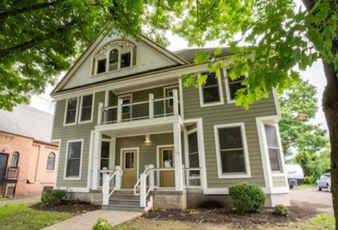 Green house with multiple windows and doors exterior at Cortland Apts. in Cortland Student Accommodation