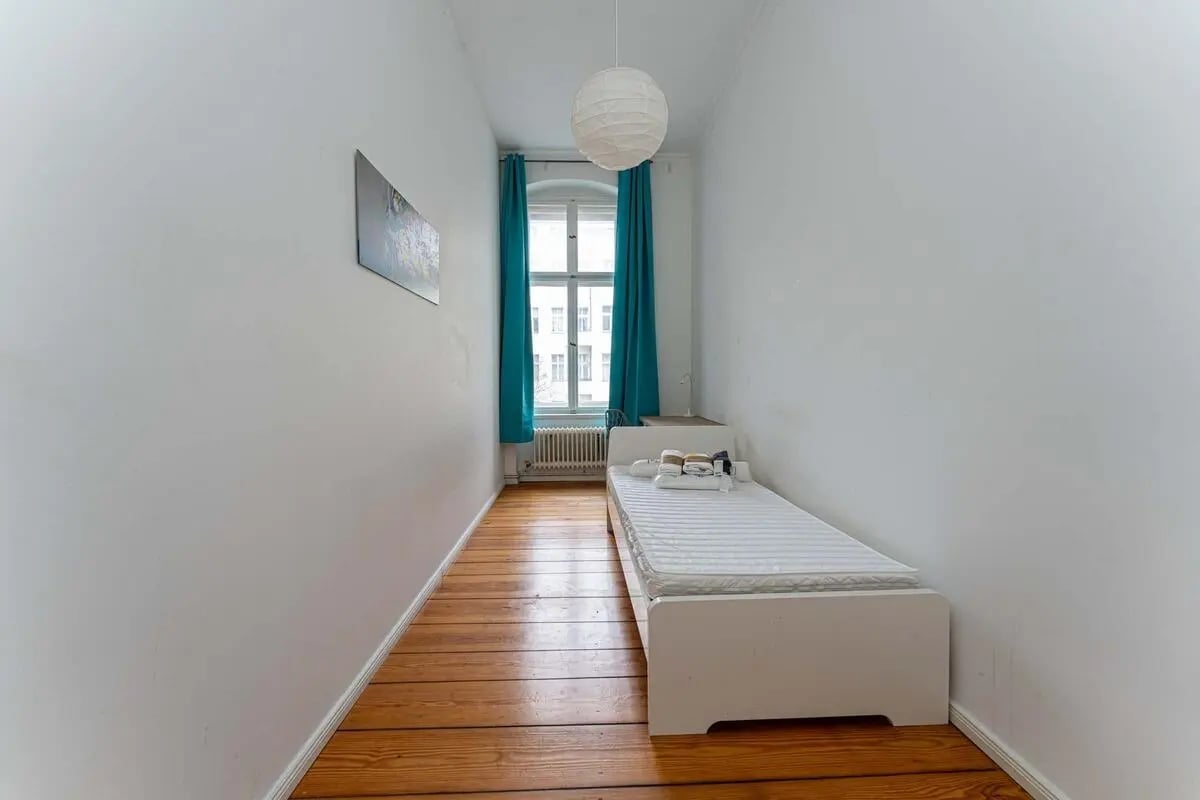 Single bed with towels teal curtains and art bedroom at Room in Kaiser-Friedrich-Straße 48, 10627 Berlin, Germania in Berlin Student Accommodation