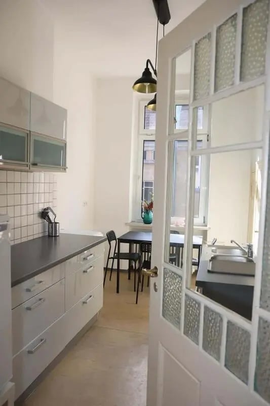 White cabinets counter sink chairs table kitchen at Room in Kantstraße 33, 10625 Berlin, Germany in Berlin Student Accommodation