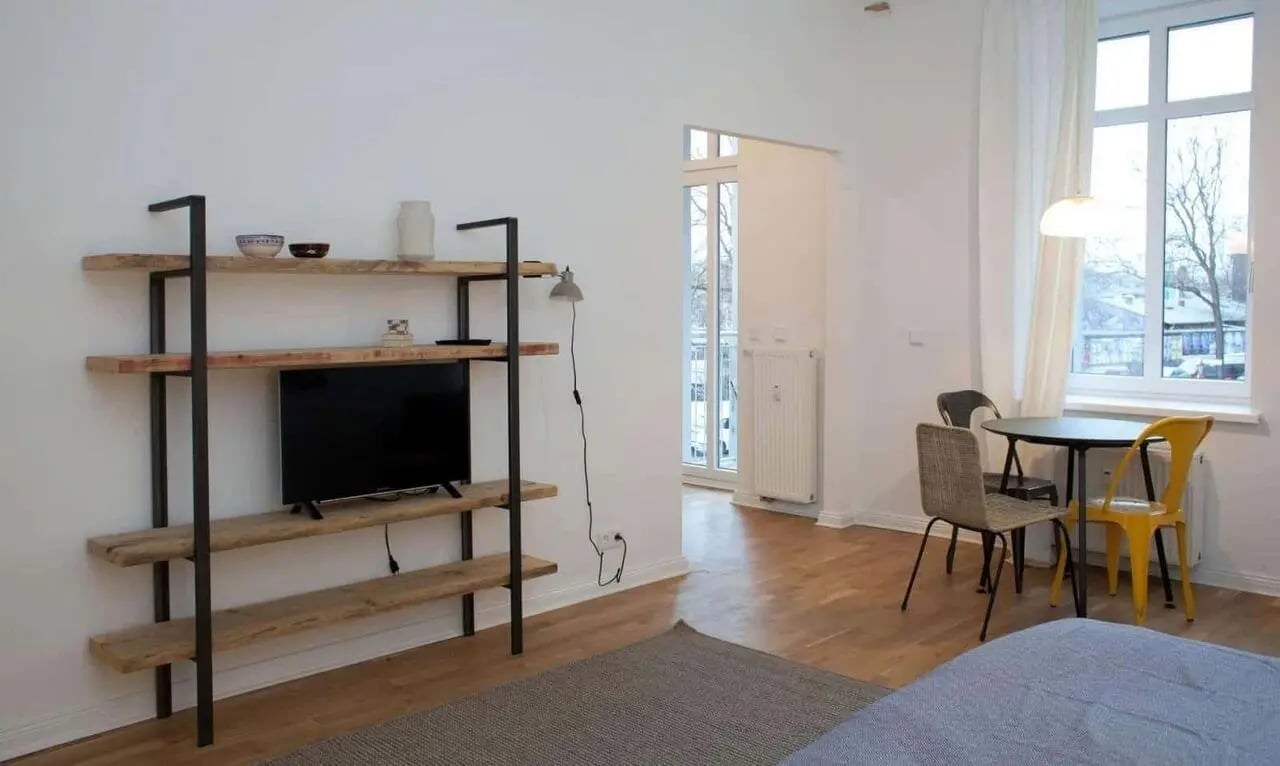 Rustic shelf with TV dining table and chairs Living room at Studio in Dirschauer Str., 10245 Berlin-Bezirk Friedrichshain-Kreuzberg, Germany in Berlin Student Accommodation