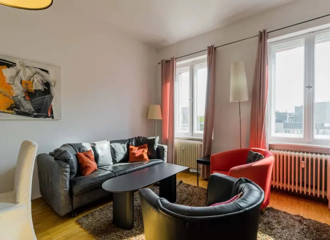 Black sofa and red chairs with coffee table living room at Apartment in Dahlmannstraße, 10629 Berlin-Bezirk Charlottenburg-Wilmersdorf, Germany in Berlin Student Accommodation