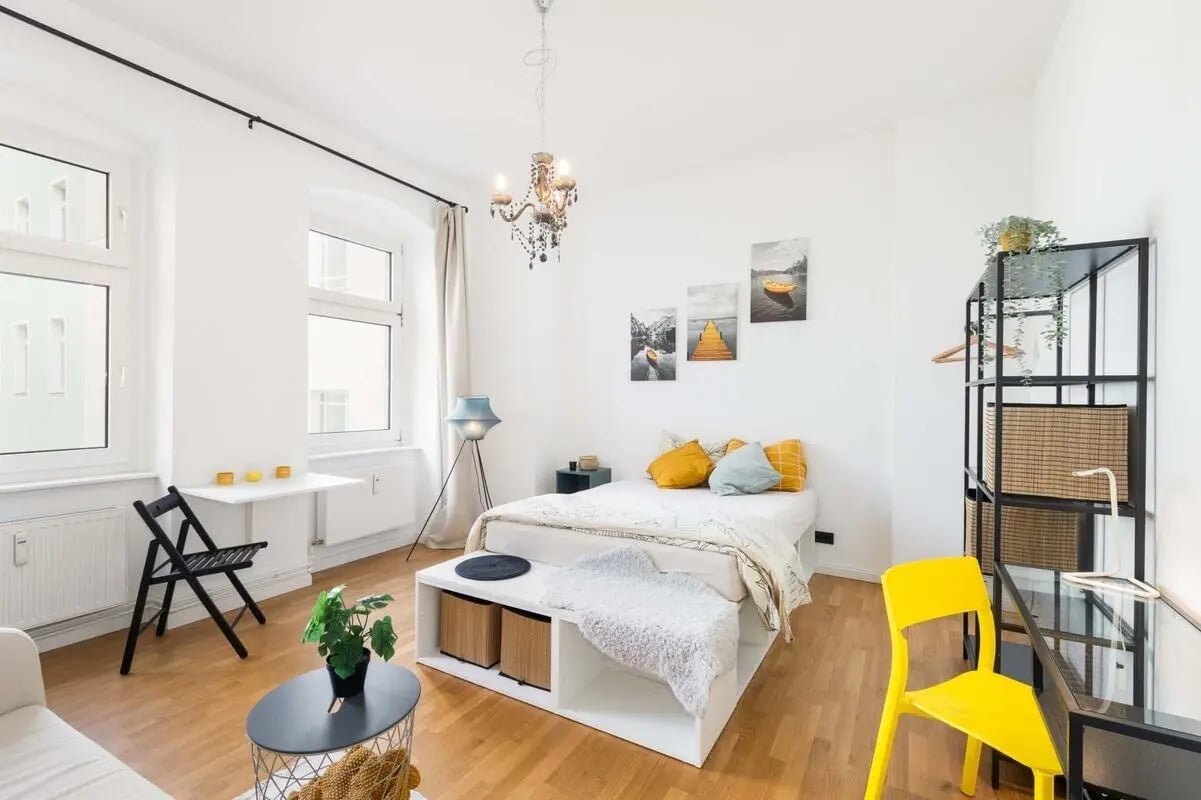 Bed storage shelving desk yellow chair bedroom at Studio in Gotenstraße 10, 10829 Berlin, Allemagne in Berlin Student Accommodation