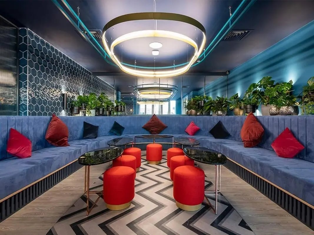 Blue couches red stools black tables living area at Silk Mill Edinburgh in Edinburgh Student Accommodation