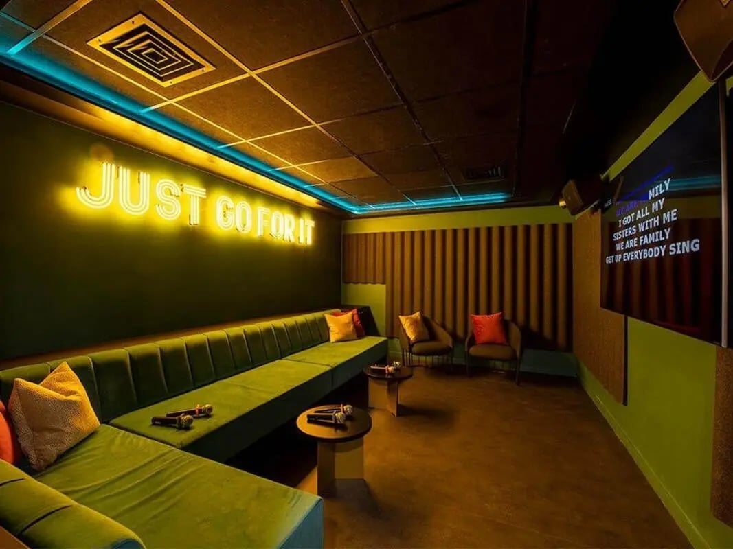 Green sofa microphones neon sign karaoke room at Bridle Works Glasgow in Glasgow Student Accommodation