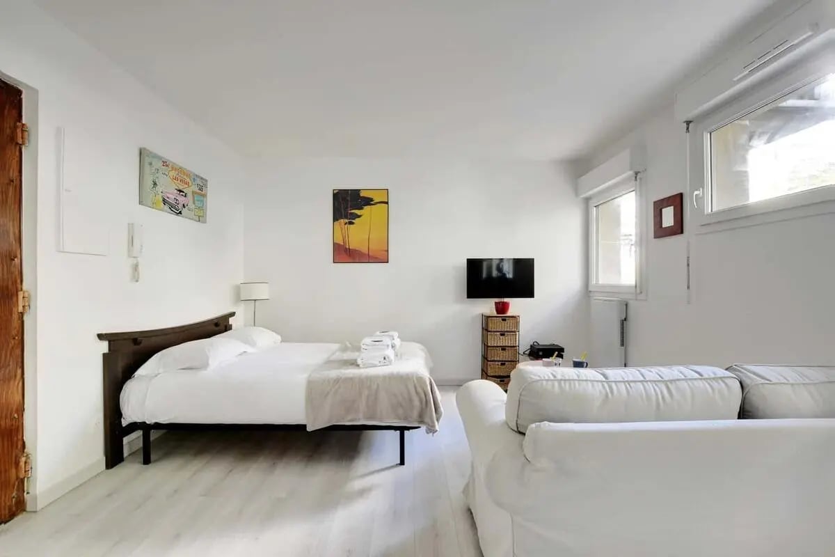 Bed white sofa television basket storage living room at Studio in 48 Av. Secrétan, 75019 Paris, France in Paris Student Accommodation