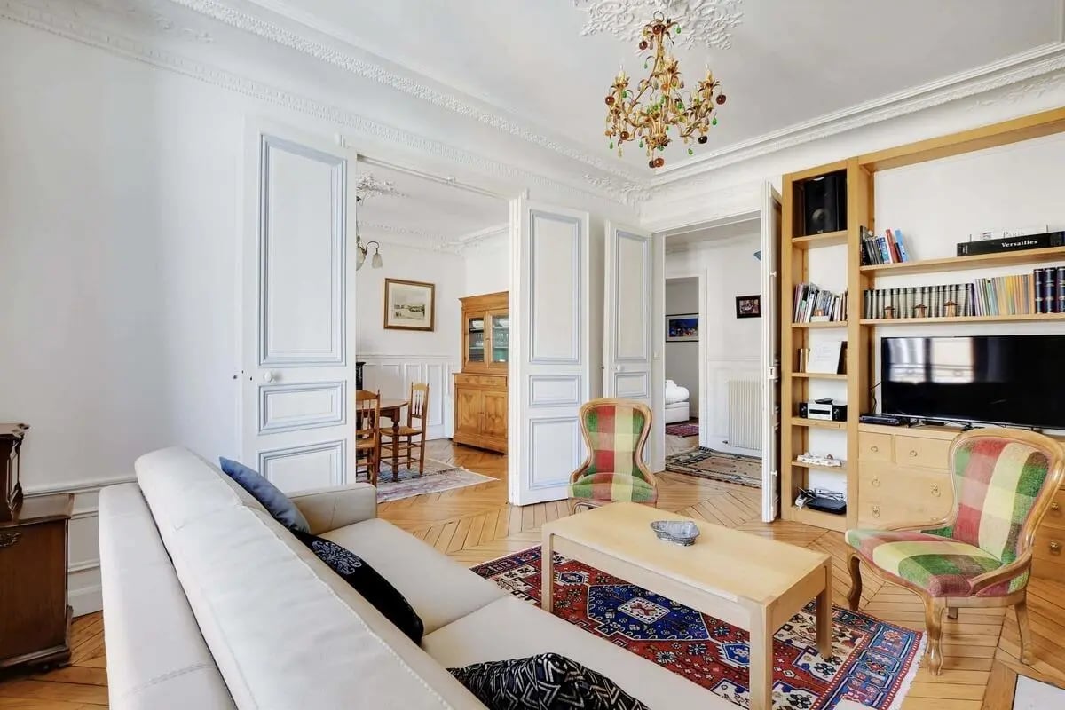 White couch coffee table patterned rug colorful chair living room at Apartment in 3 Rue de Valenciennes, 75010 Paris, France in Paris Student Accommodation