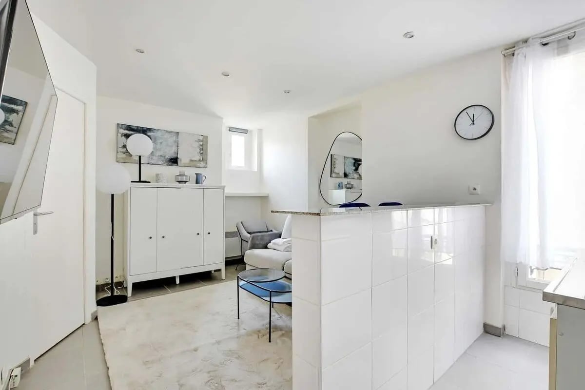 White kitchen bar with stools and living room Furniture Interior at Studio in 70 R. de Lévis, 75017 Paris, France in Paris Student Accommodation
