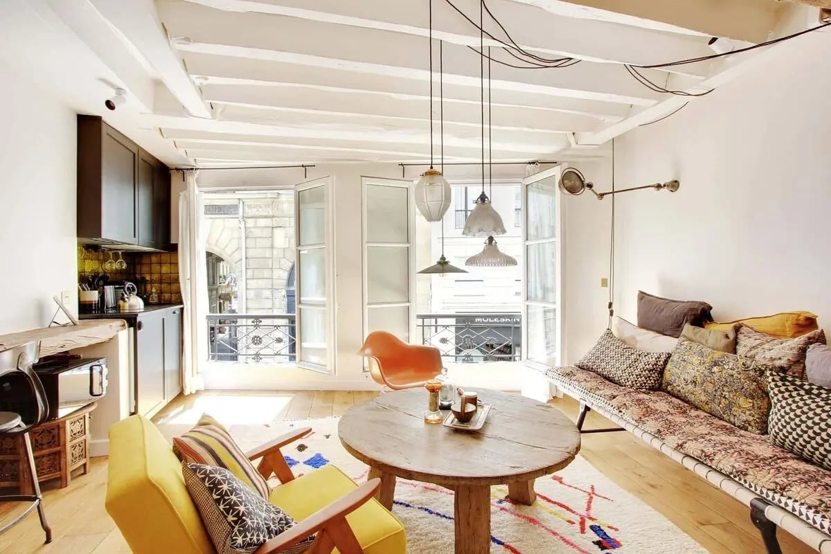 Kitchen, two chairs, table, sofa, windows, living area at Studio in 70 Rue Saint-André des Arts, 75006 Paris, France in Paris Student Accommodation