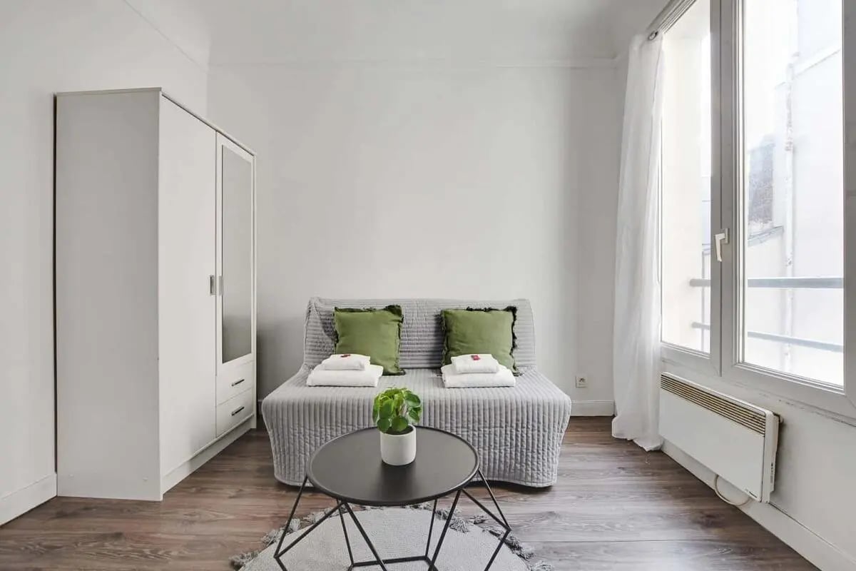 Wardrobe sofa pillows plant table bedroom at Studio in 6 Imp. de la Défense, 75018 Paris, France in Paris Student Accommodation