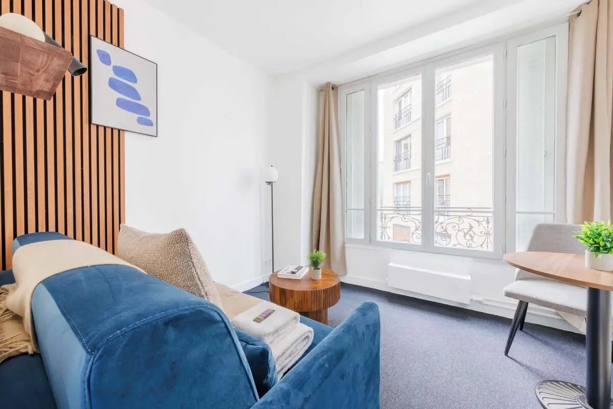 Blue sofa wooden table with plant living room at Studio in 24 Rue Gutenberg, 75015 Paris, France in Paris Student Accommodation