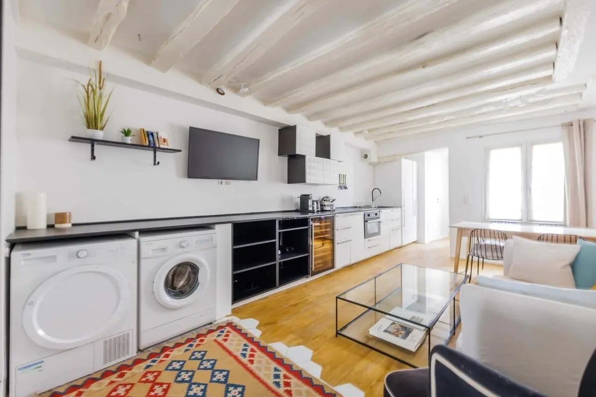 Washing machines TV and kitchen area living room at Apartment in 127 Rue Saint-Honoré, 75001 Paris, France in Paris Student Accommodation