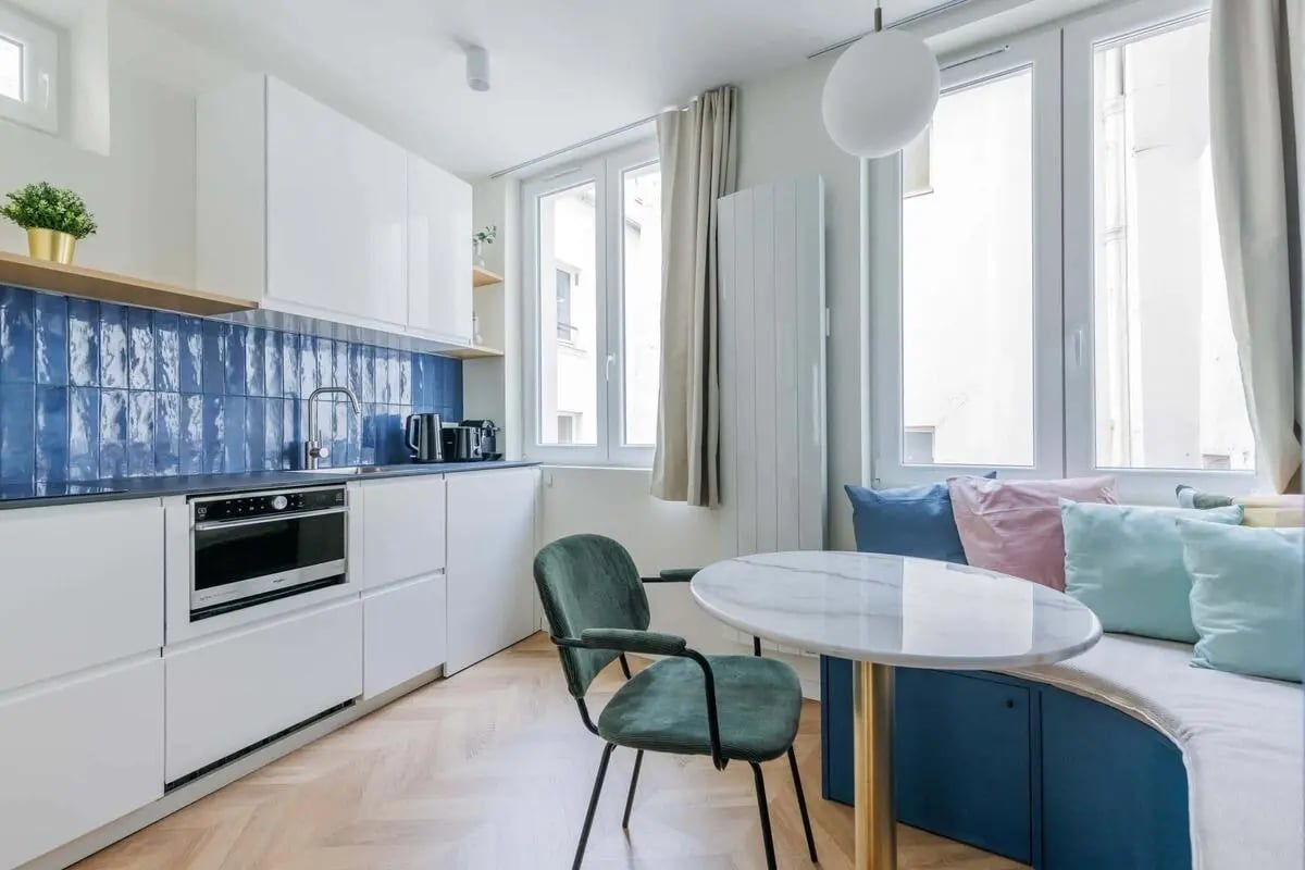 Modern kitchen with blue tile and marble dining table kitchen at Apartment in 8 Rue des Ciseaux, 75006 Paris, France in Paris Student Accommodation