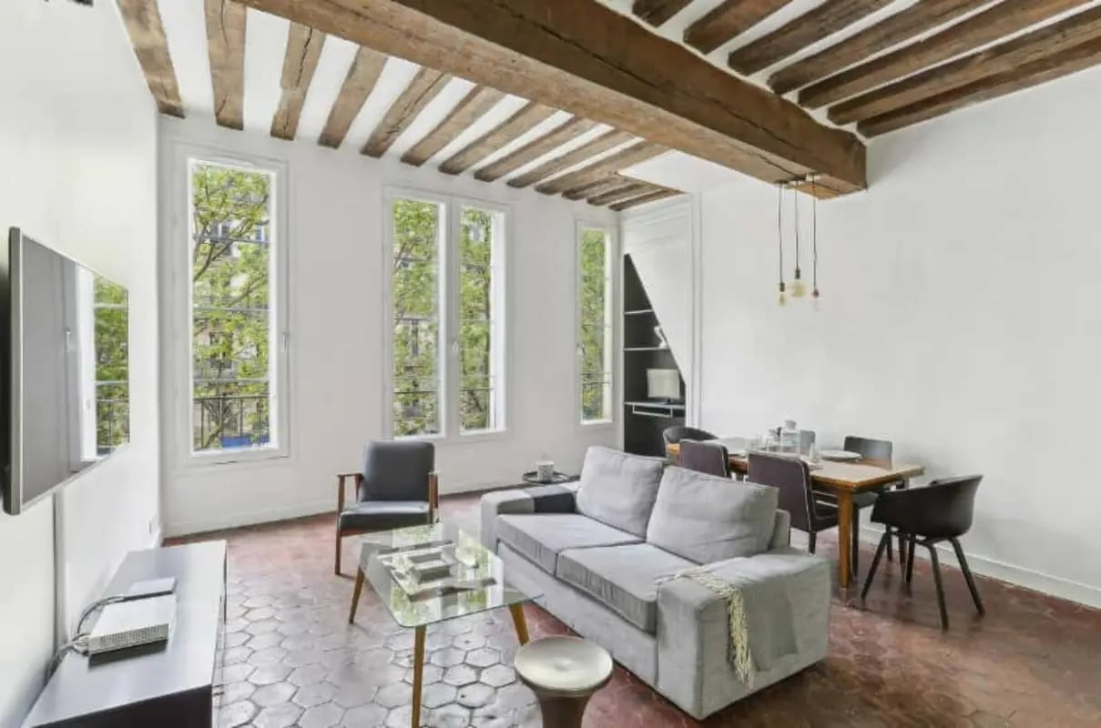 Sofa chairs dining table television exposed beams living room at Apartment in 152 Bd Saint-Germain, 75006 Paris, France in Paris Student Accommodation