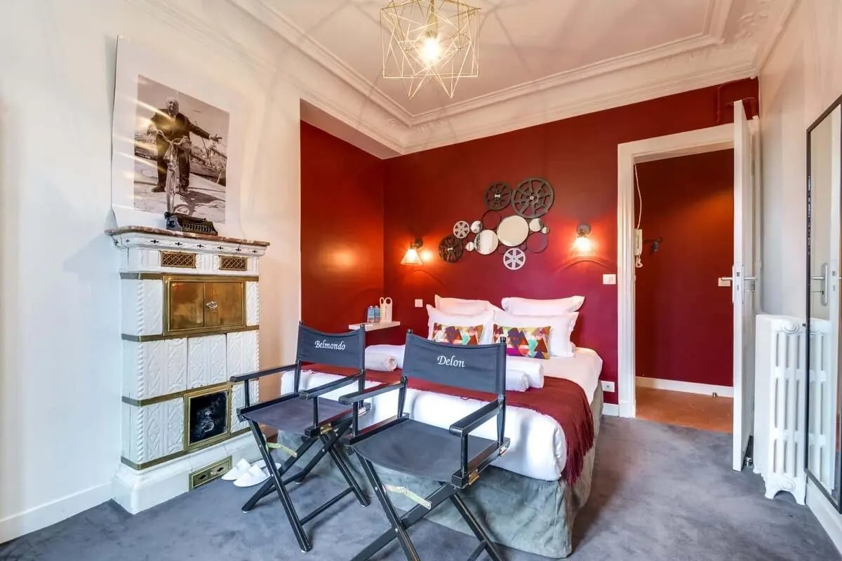 Tiled stove two director chairs bed bedroom at Apartment in 138 Bd Saint-Germain, 75006 Paris, France in Paris Student Accommodation
