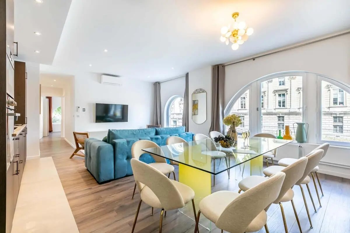 Blue sofa glass dining table and chairs living area at Apartment in 42 Quai des Orfèvres, 75001 Paris, France in Paris Student Accommodation