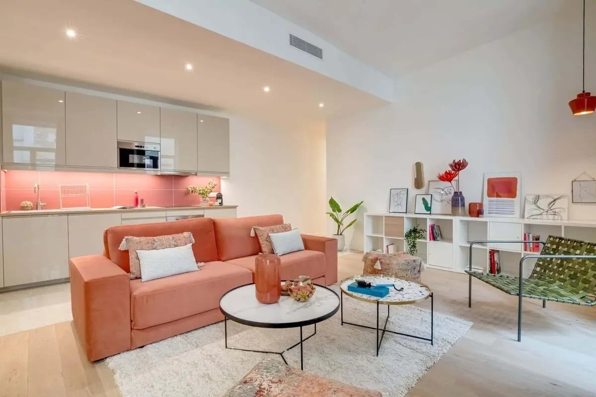 Pink sofa, kitchen, coffee tables, shelves, chair living room at Apartment in 132 Rue de Turenne, 75003 Paris, France in Paris Student Accommodation