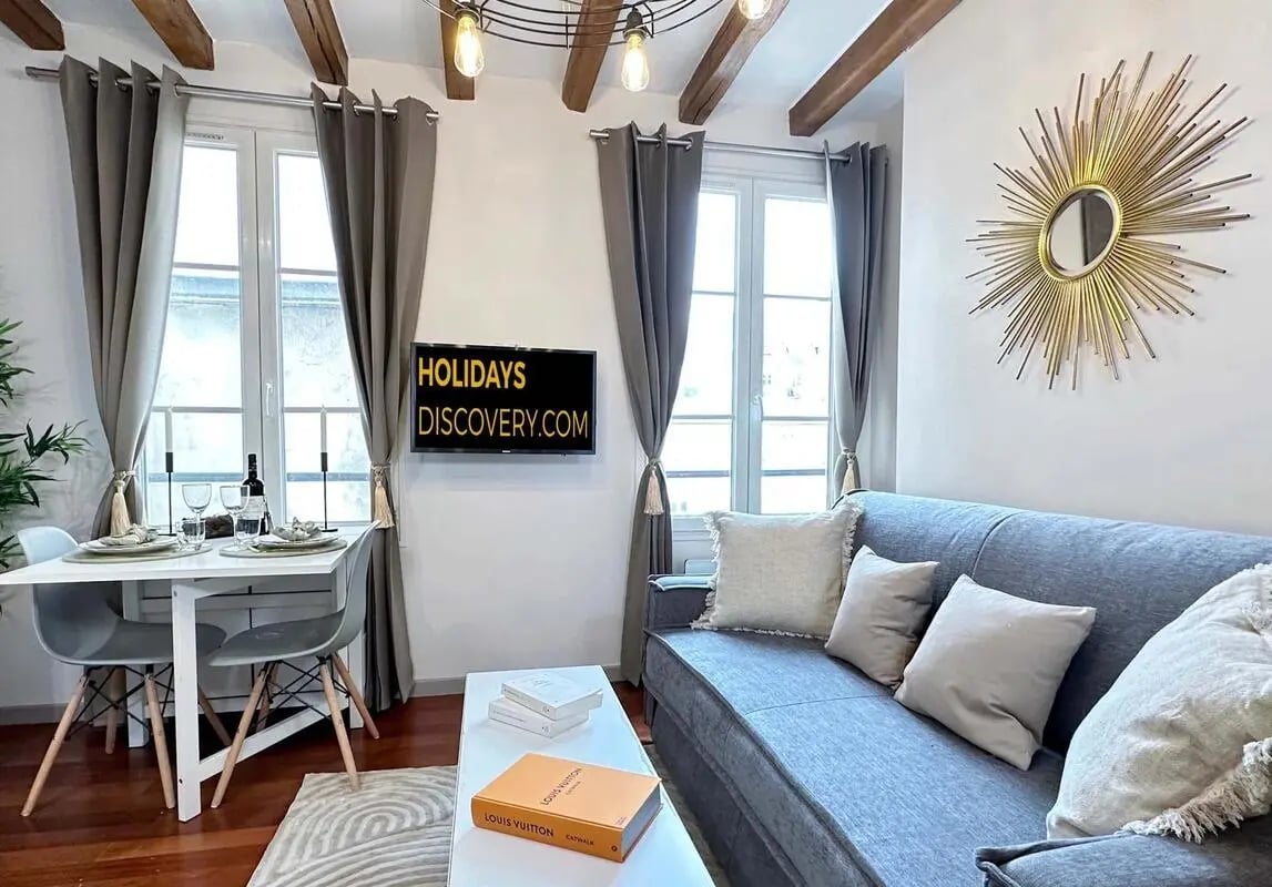 Gray sofa dining table and decorative mirror living room at Apartment in 145 Rue Saint-Dominique, 75007 Paris, France in Paris Student Accommodation
