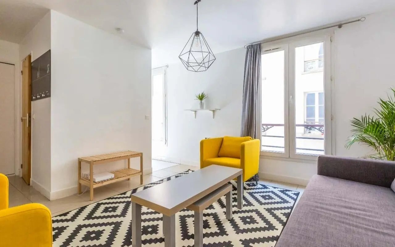 Yellow armchair grey sofa coffee table rug living room at Studio in Av. de Flandre, 75019 Paris, France in Paris Student Accommodation