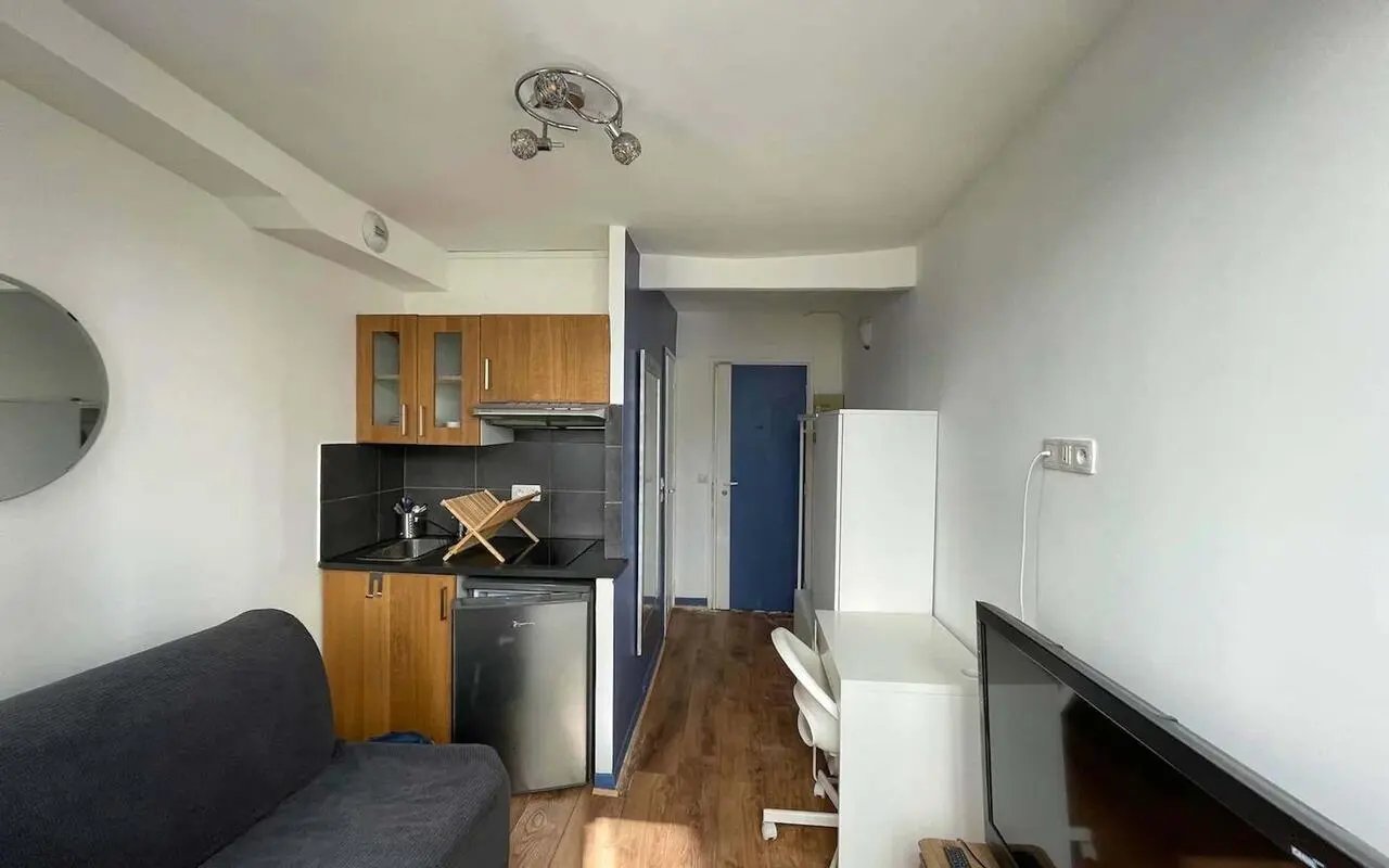 Sofa small kitchen desk TV living room at Studio in Rue de Saussure, 75017 Paris, France in Paris Student Accommodation