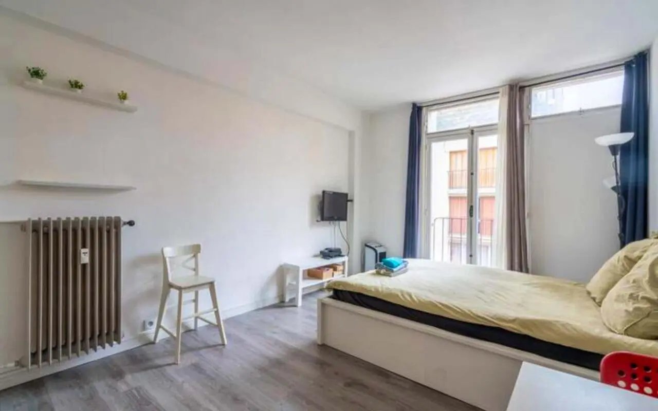 Bed radiator chair TV stand bedroom at Studio in Rue Guyton de Morveau, 75013 Paris, France in Paris Student Accommodation