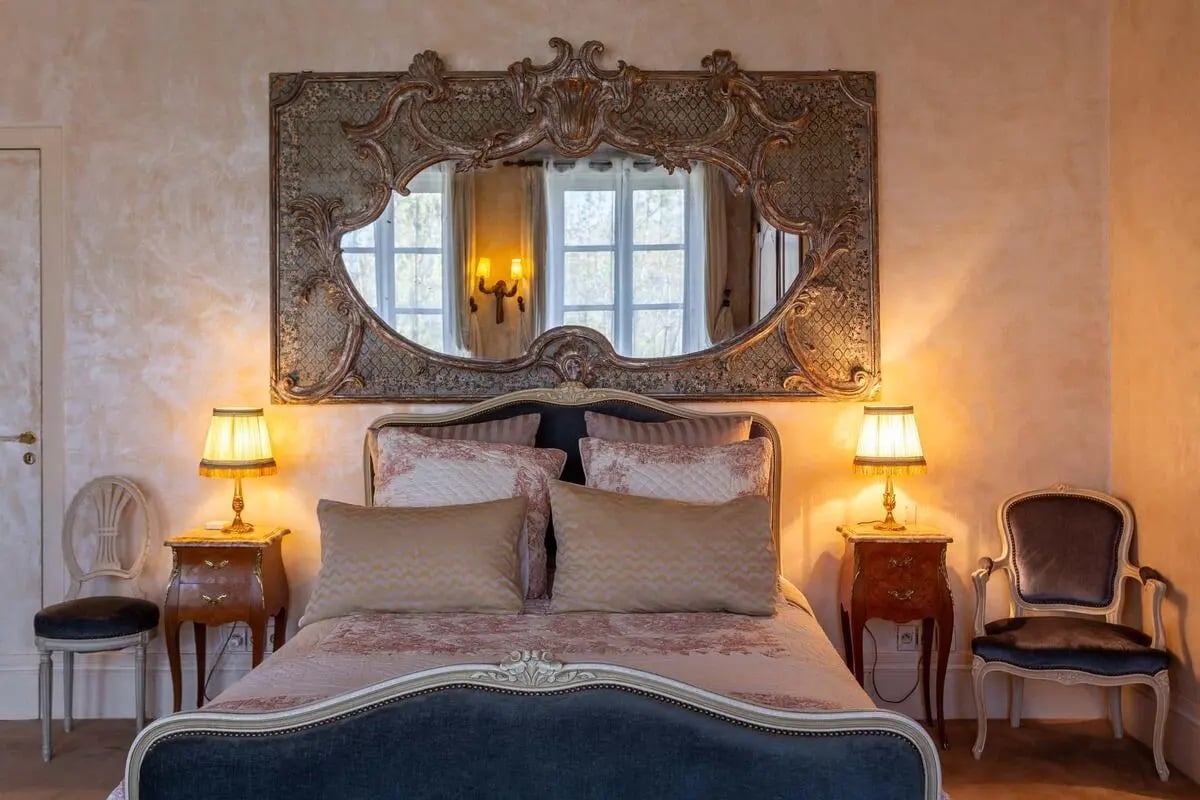 Ornate mirror over bed with decorative pillows and chairs bedroom at Studio in 56 Quai des Orfèvres, 75001 Paris, Francia in Paris Student Accommodation