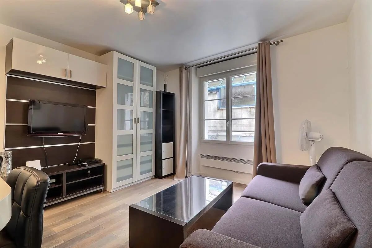 Sofa cabinet TV fan and coffee table living room at Studio in Rue Poissonnière, 75002 Paris, France in Paris Student Accommodation