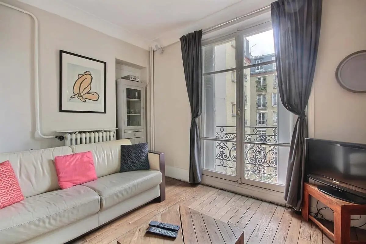 White sofa artwork tall cabinet large window living room at Apartment in Rue Eugène Millon, 75015 Paris, France in Paris Student Accommodation