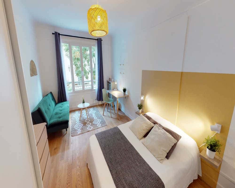 Bed with yellow headboard green sofa desk bedroom at Room in 368 Rue de Vaugirard, 75015 Paris, France in Paris Student Accommodation